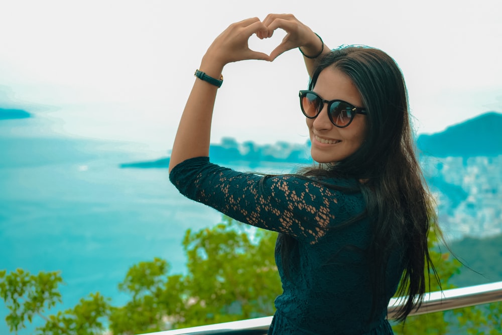 a woman making a heart shape with her hands