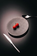 Minimalist food photography setup featuring a vibrant red sauce splash on a white plate.