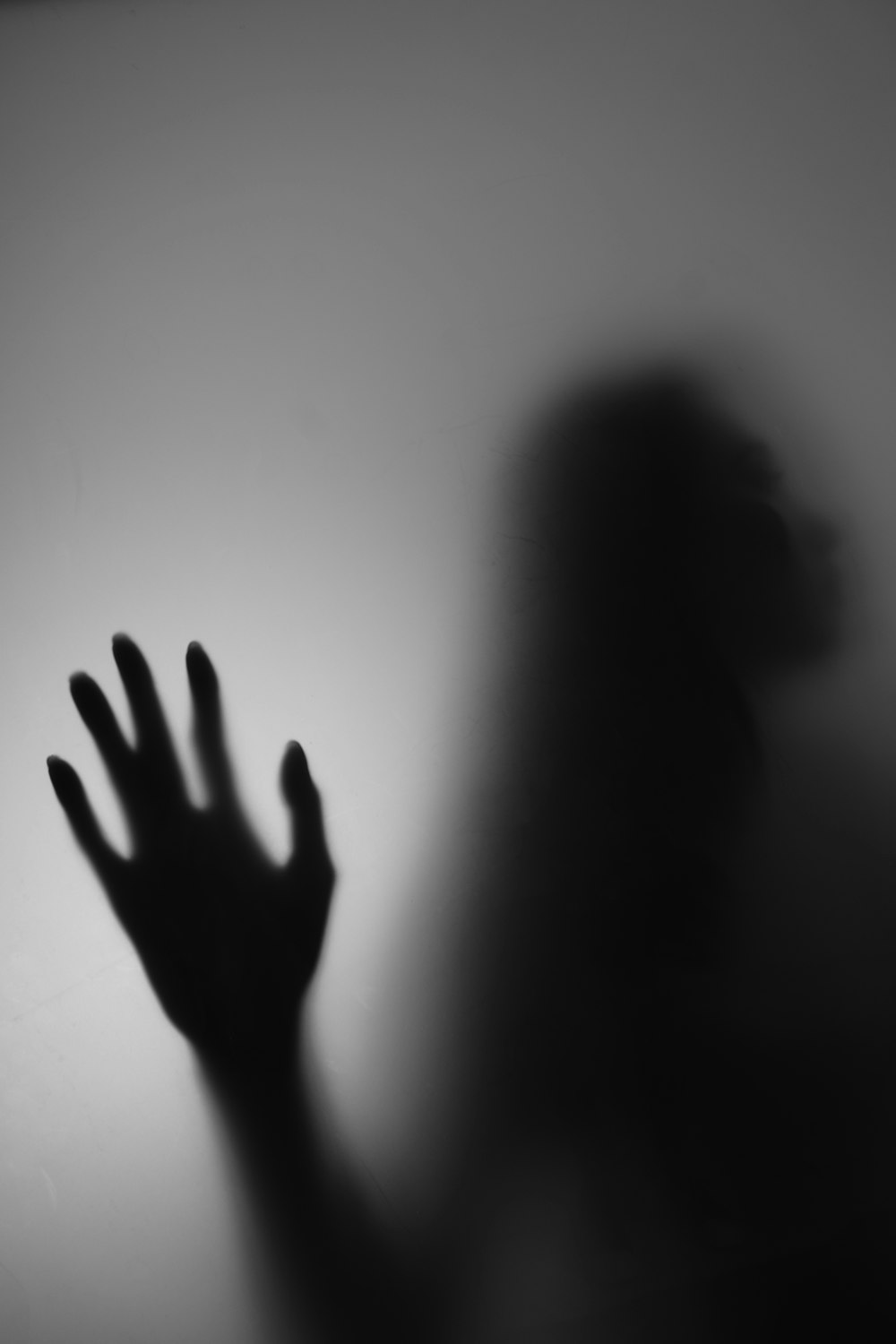 Ein Schatten einer Person, die ihre Hand hochhält