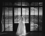 A serene portrait of a bride looking thoughtfully out a window.