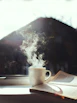 A cozy corner with a steaming cup of coffee beside an open book and soft natural light.