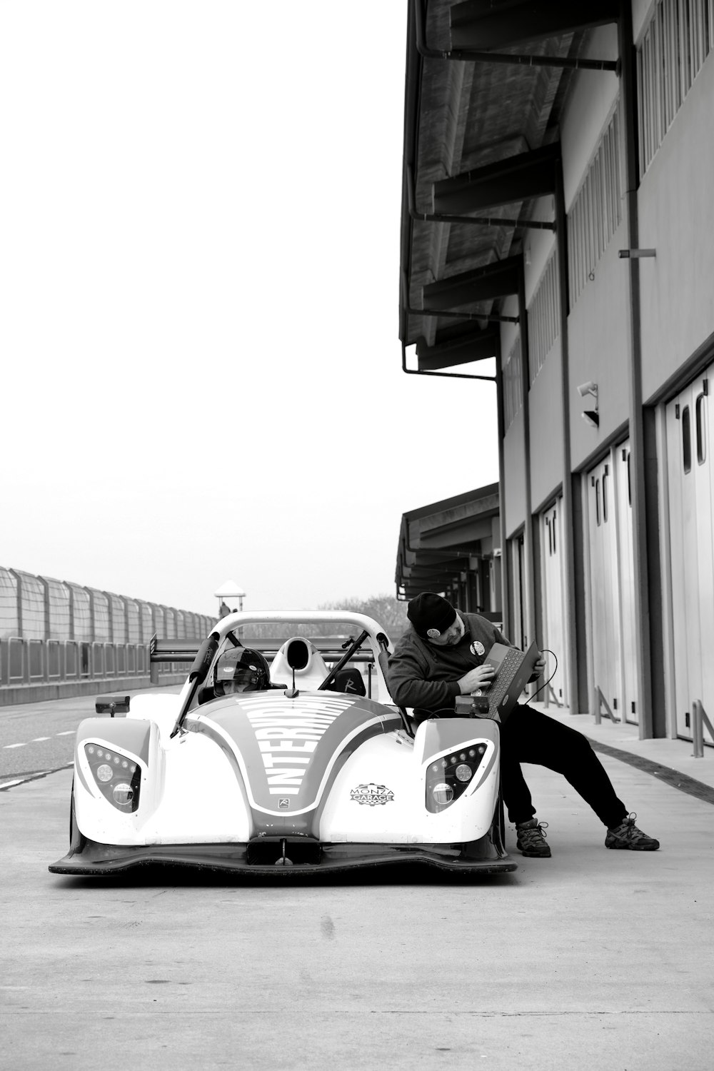a man sitting on the hood of a race car