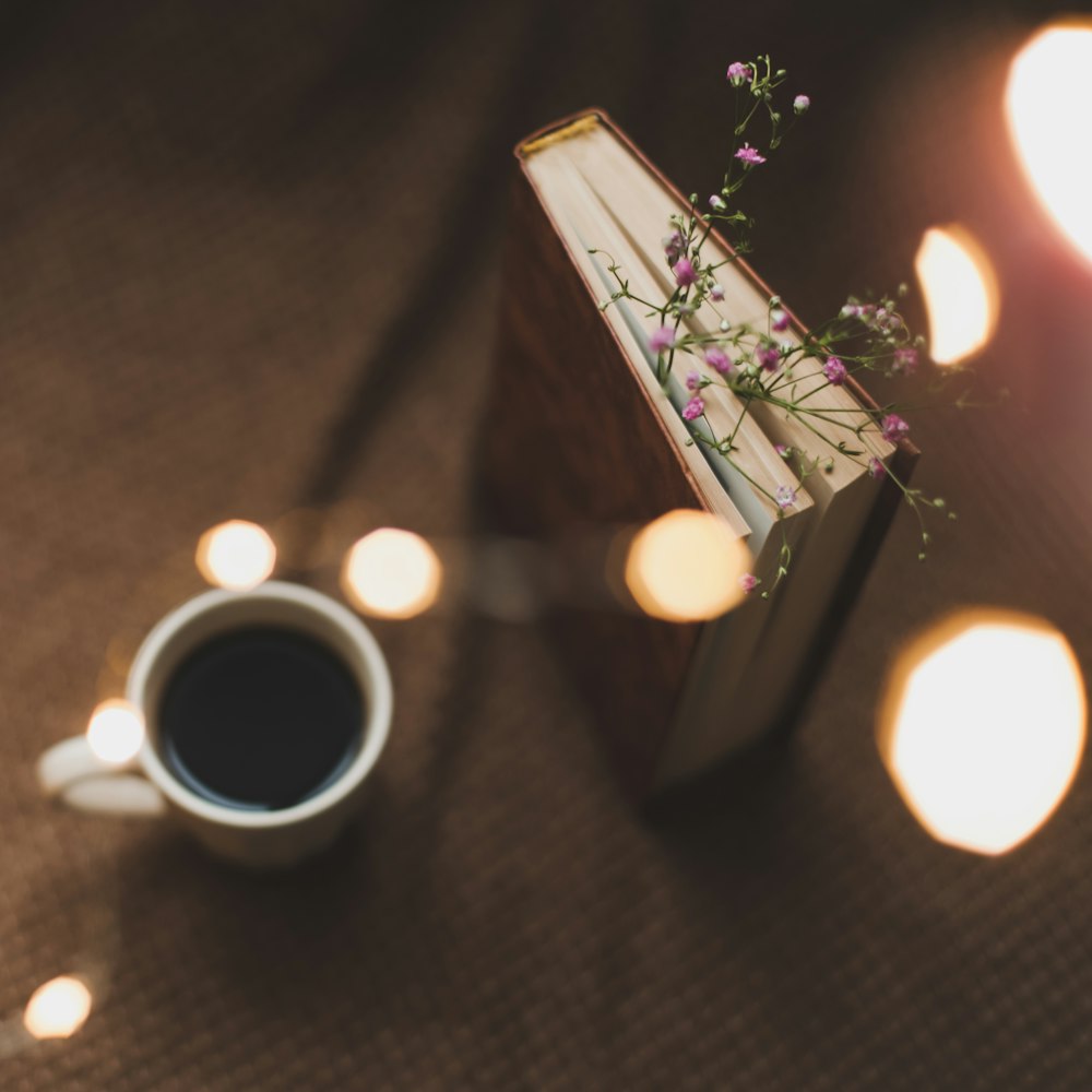 Un libro y una taza de café sobre una mesa