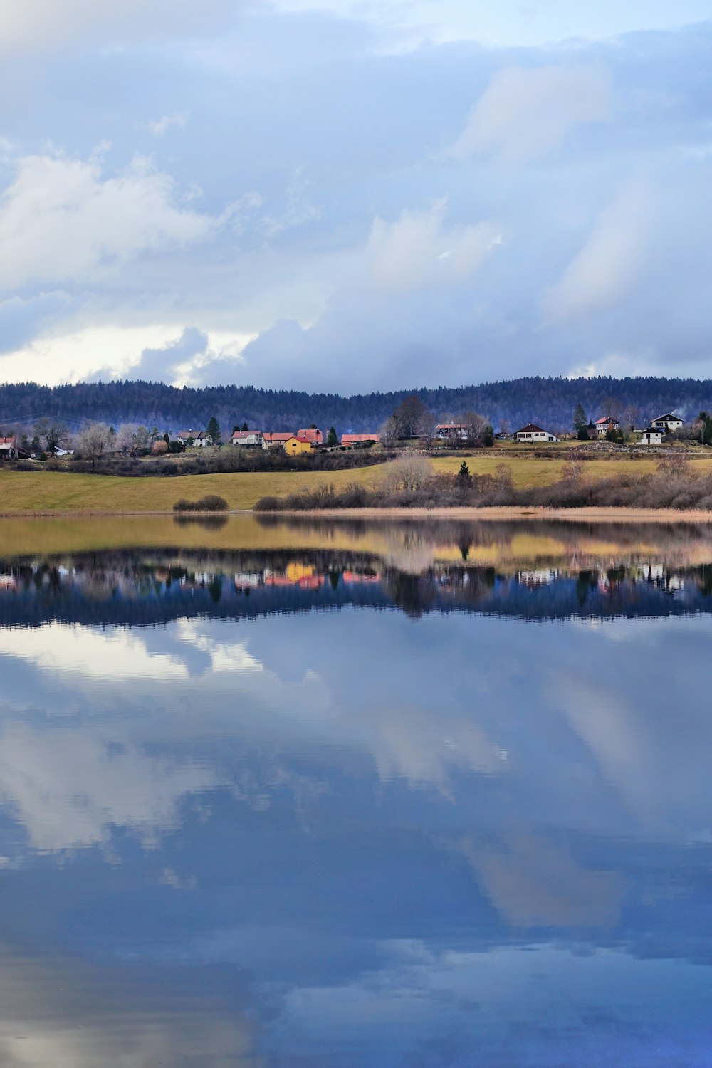 a body of water surrounded by a lush green hillside