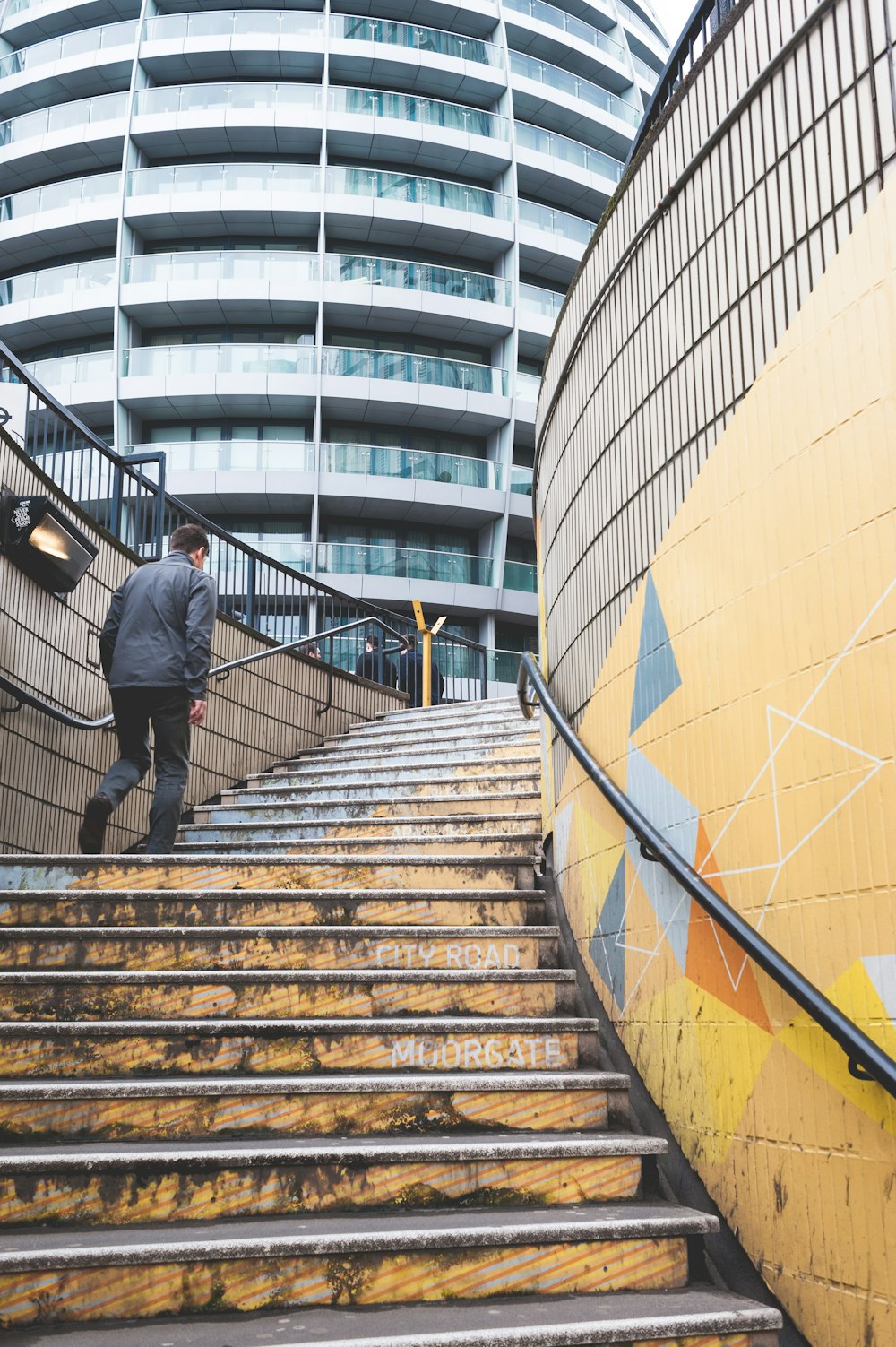 a man walking up some stairs in front of a building