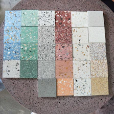 Display of various epoxy grout color samples arranged neatly on a white background.