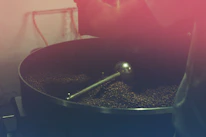 Artisan roasting process showing beans being carefully roasted over traditional equipment.