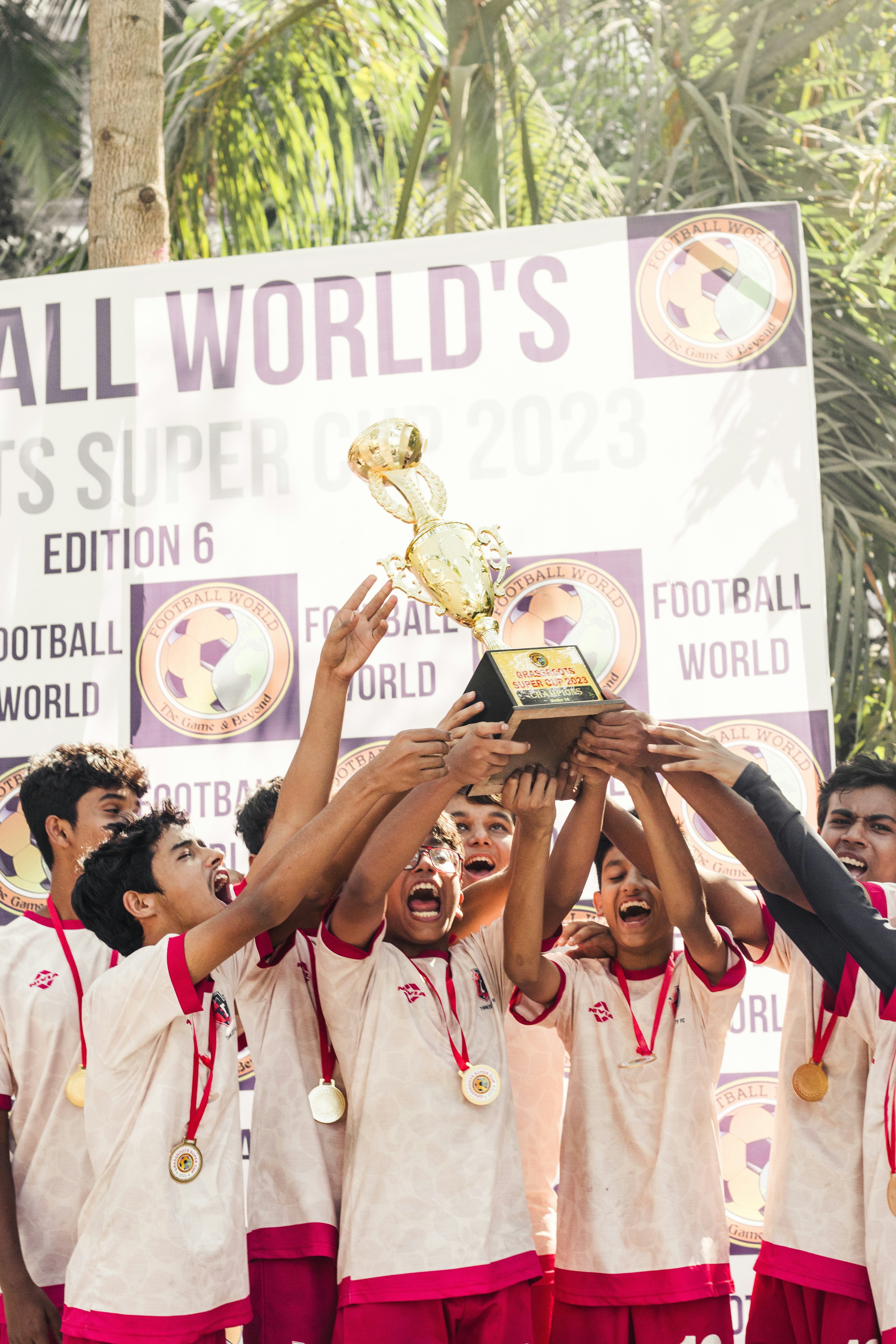 sekelompok pemuda memegang piala