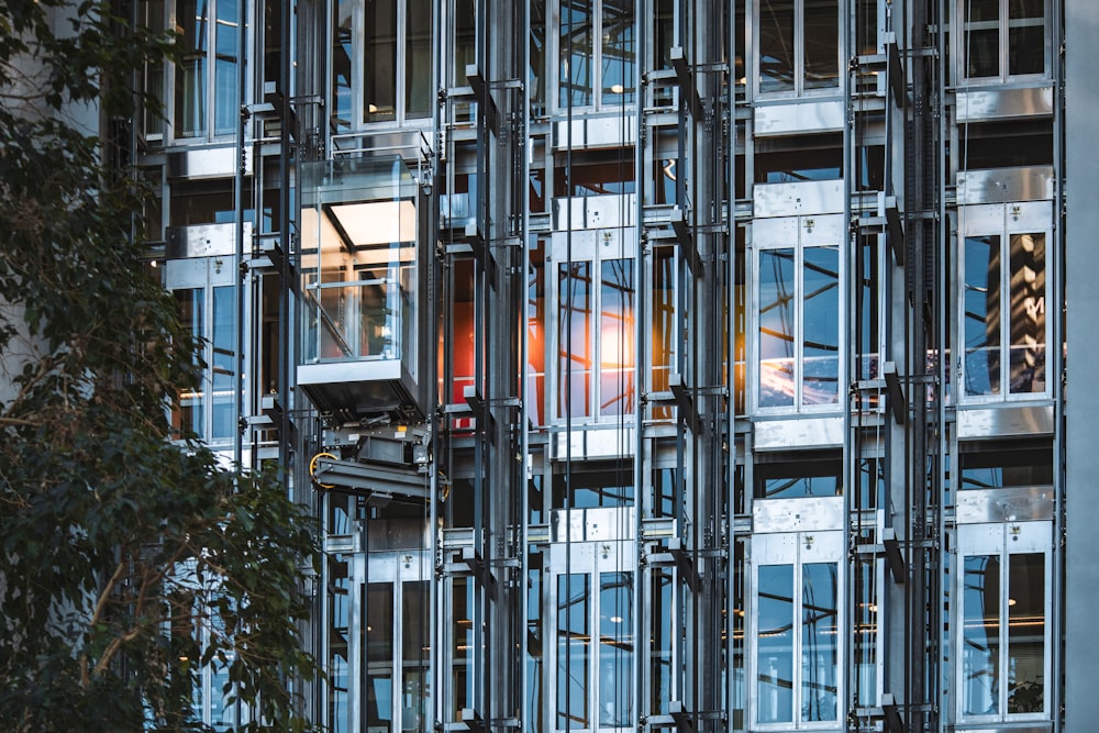 a tall building with lots of windows next to a tree