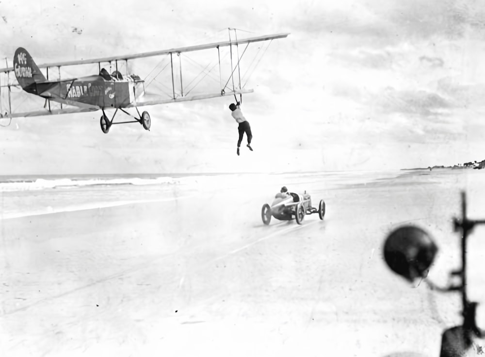 an old photo of a plane flying over a beach