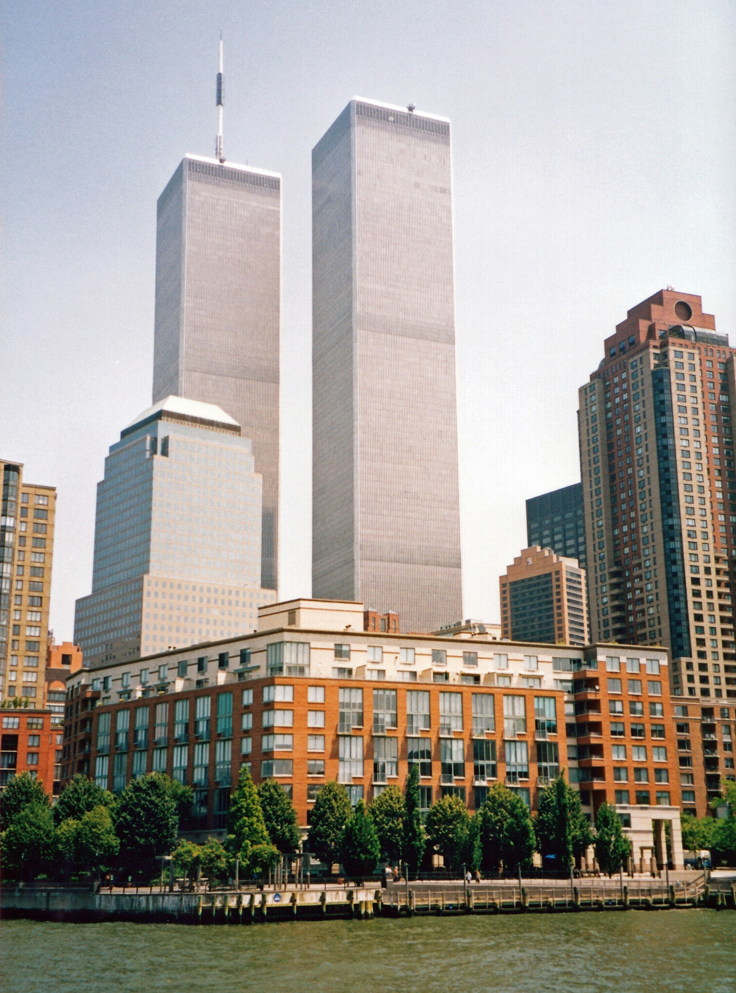 a couple of tall buildings next to a body of water