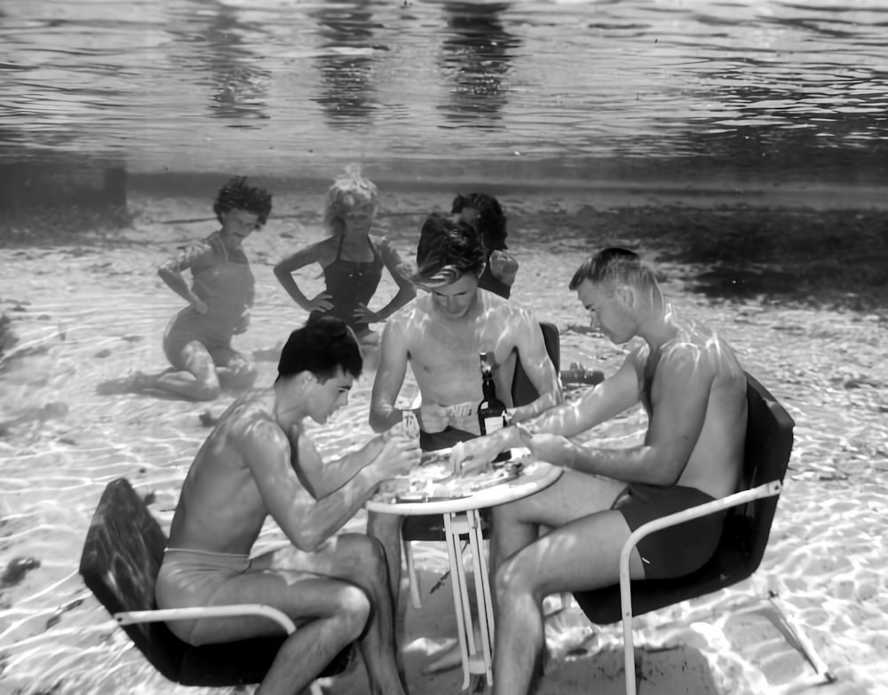 a group of people sitting around a table in the water