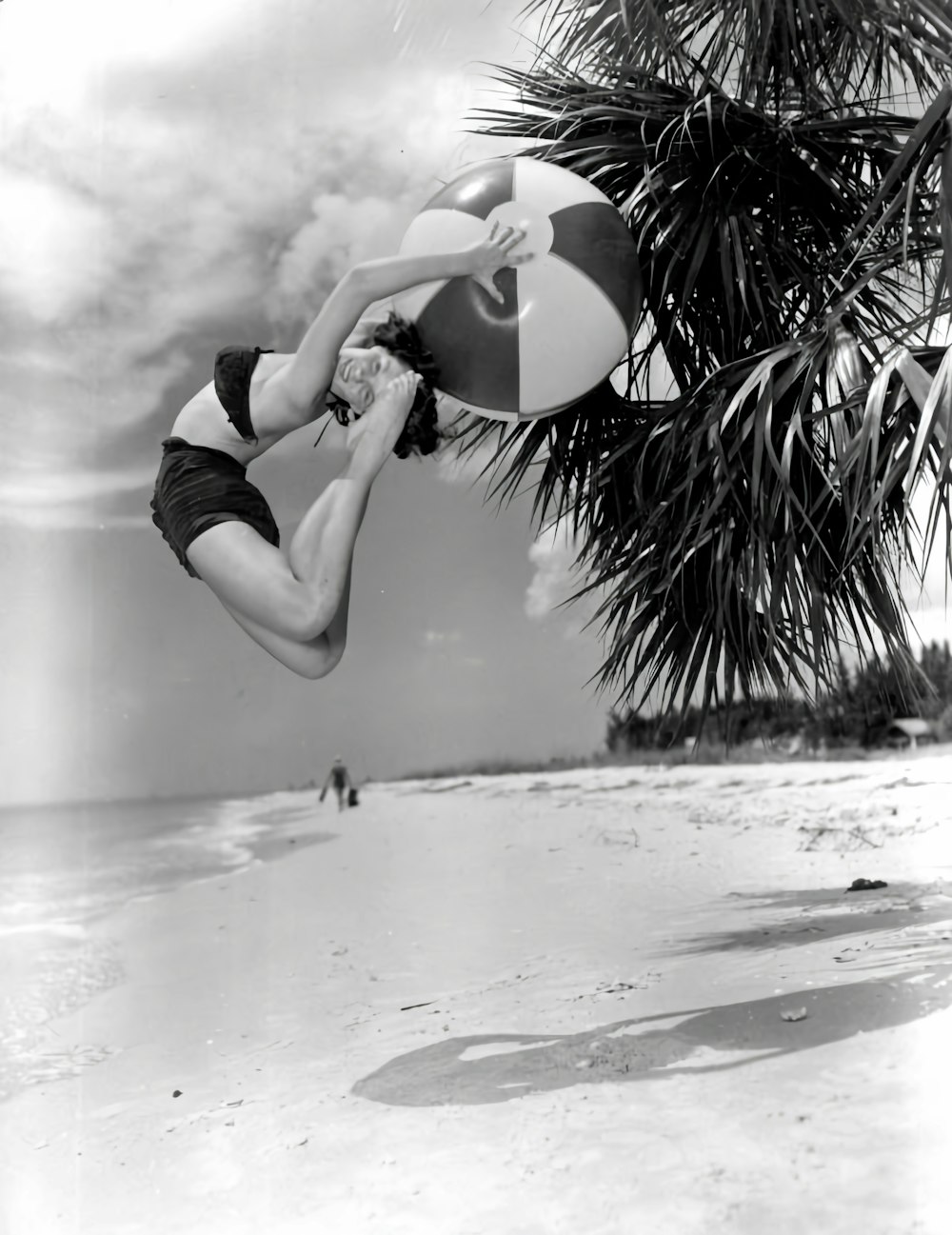 a woman jumping up into the air to catch a frisbee