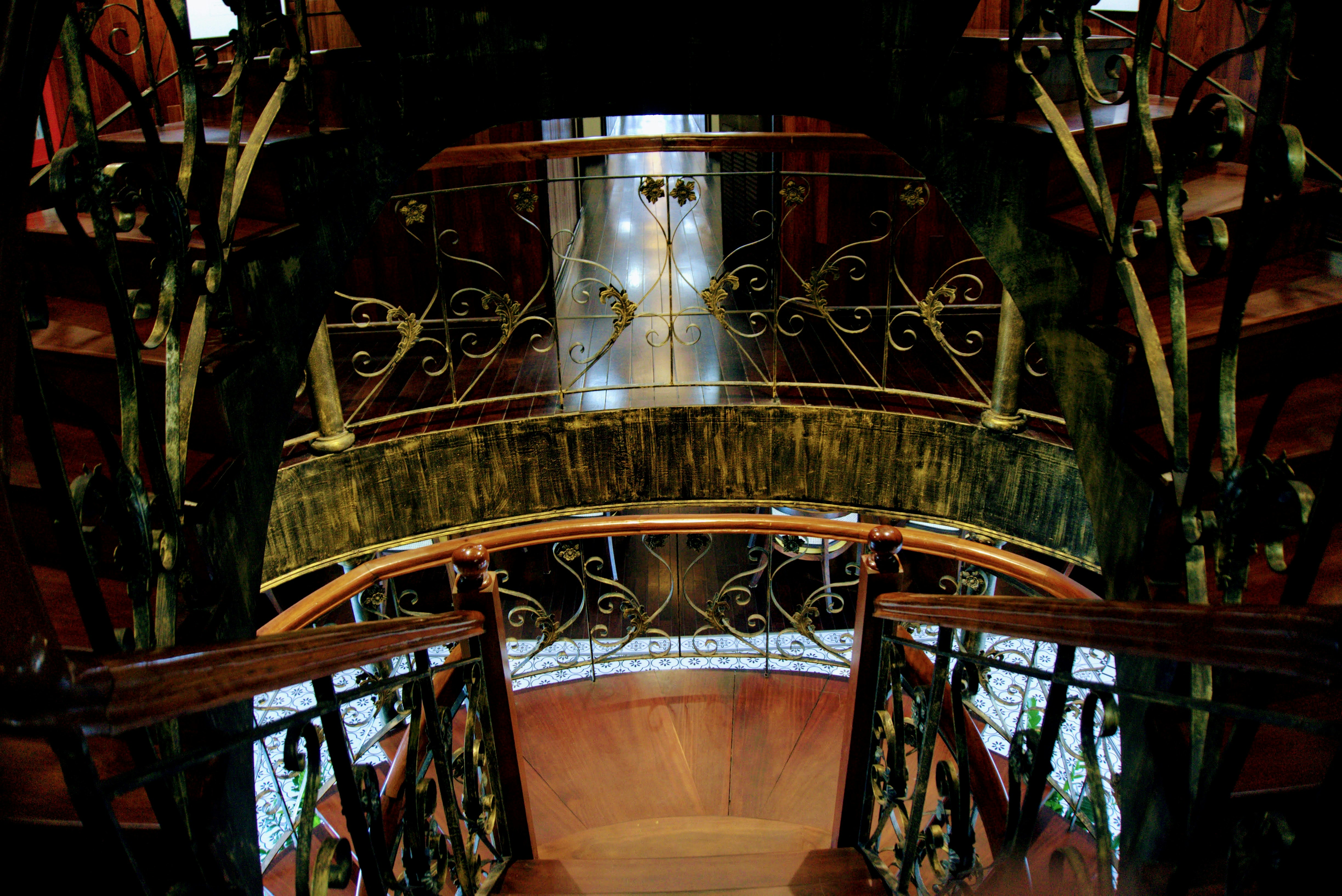 a spiral stair case in a building with a clock on it