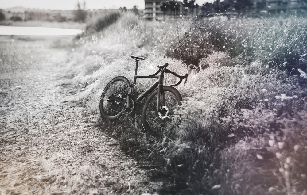 uma bicicleta estacionada ao lado de uma estrada de terra