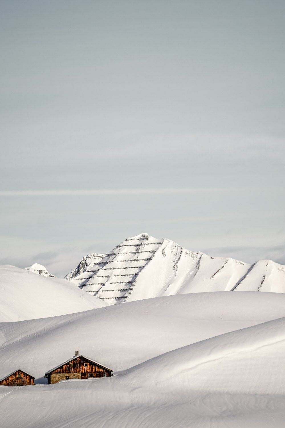 Una montaña cubierta de nieve con una casa en primer plano