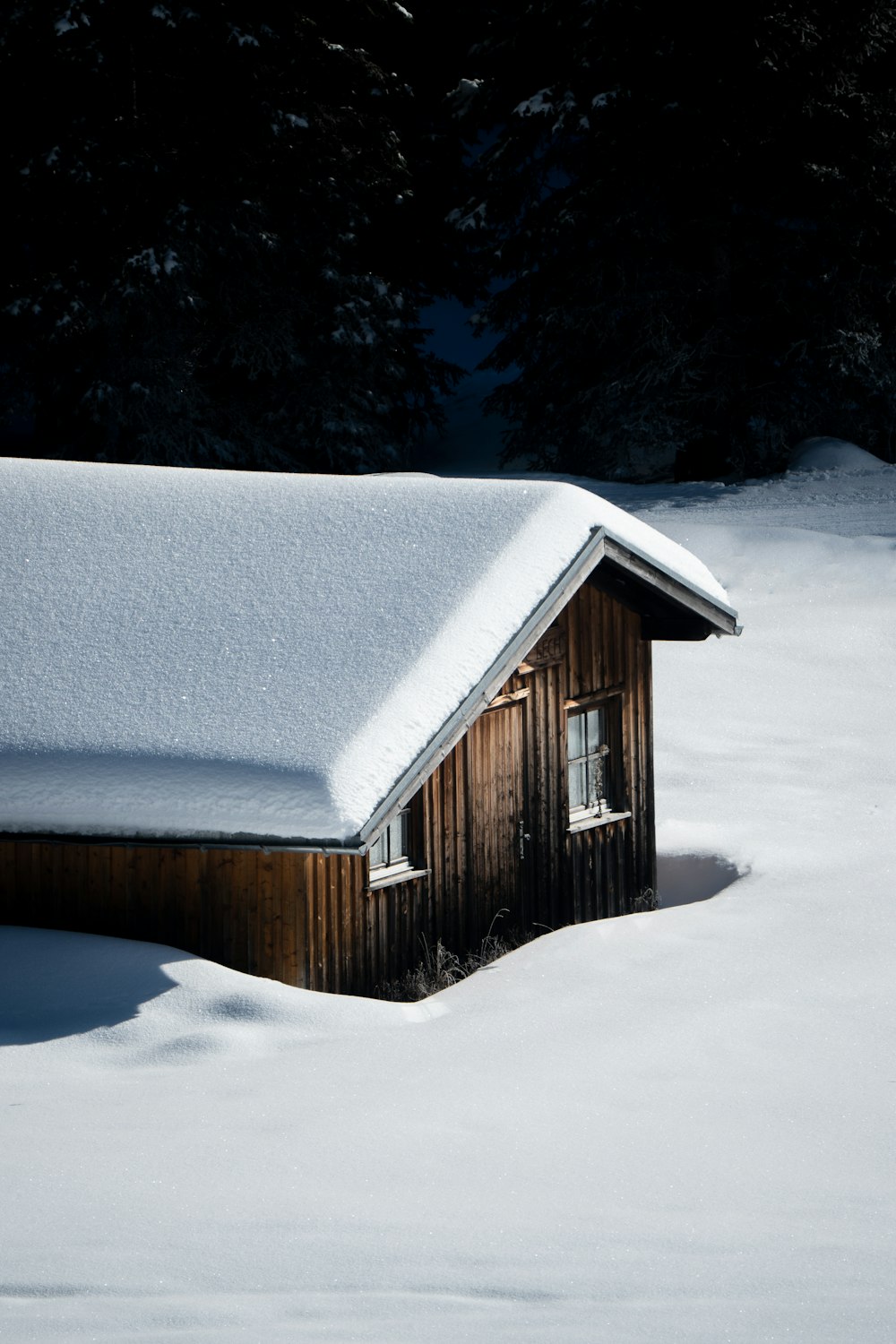 a small cabin in the middle of a snowy field