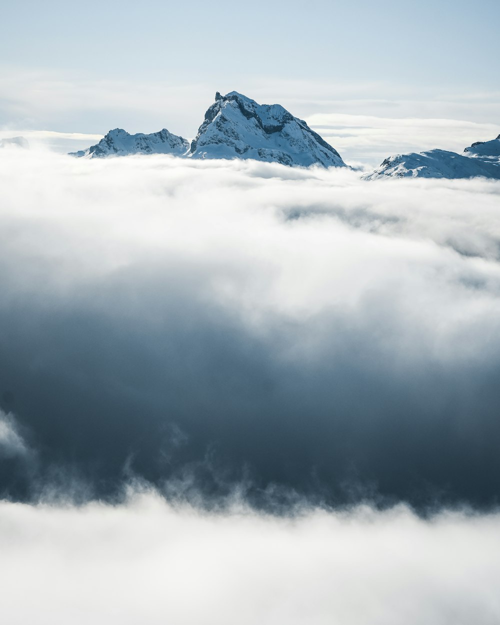 a mountain covered in clouds with a sky background