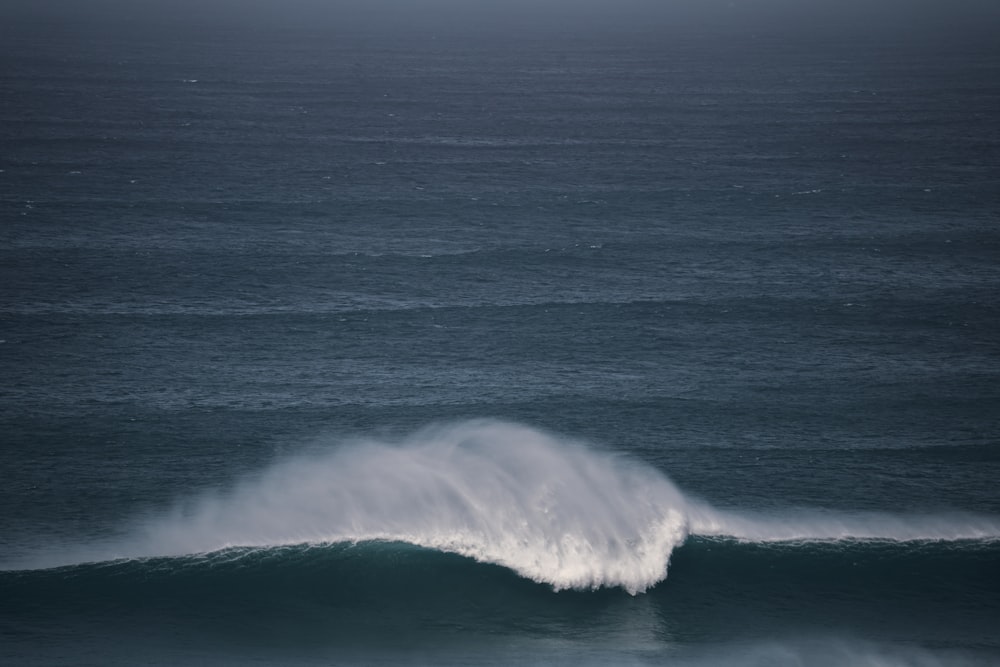 a large wave in the middle of the ocean