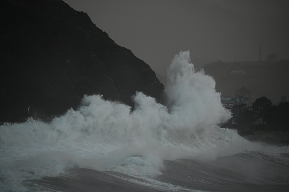 a large wave crashing into the shore of a beach