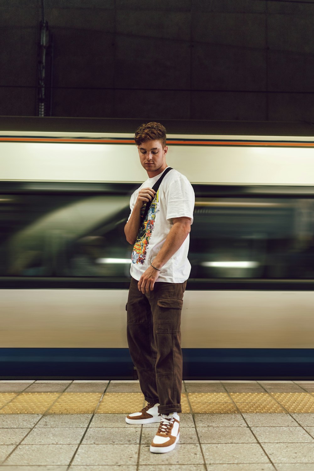 a man standing in front of a subway train