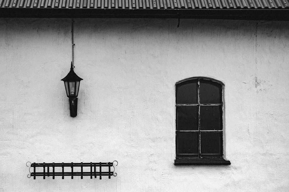 a black and white photo of a window and a bench