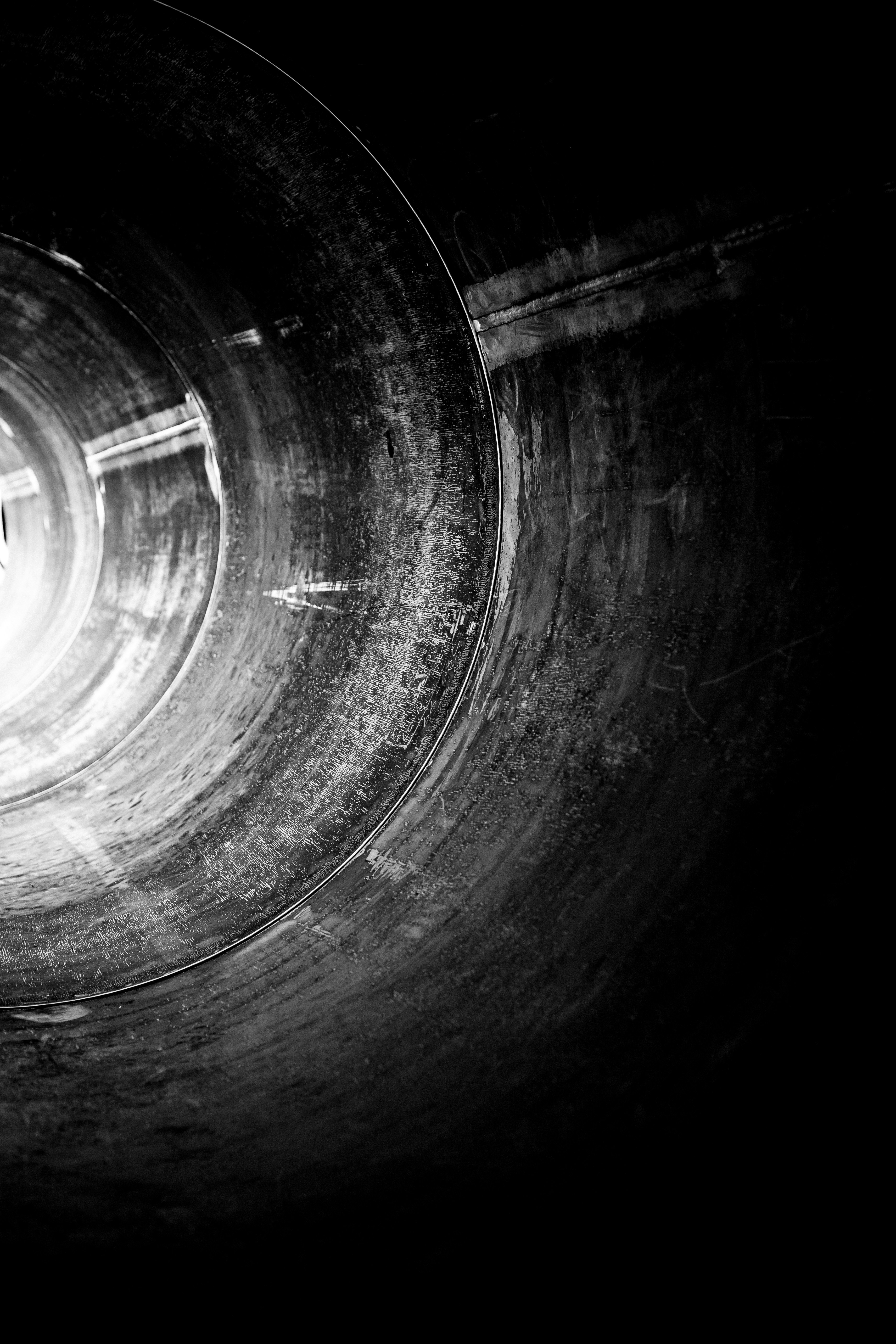 a black and white photo of a light at the end of a tunnel