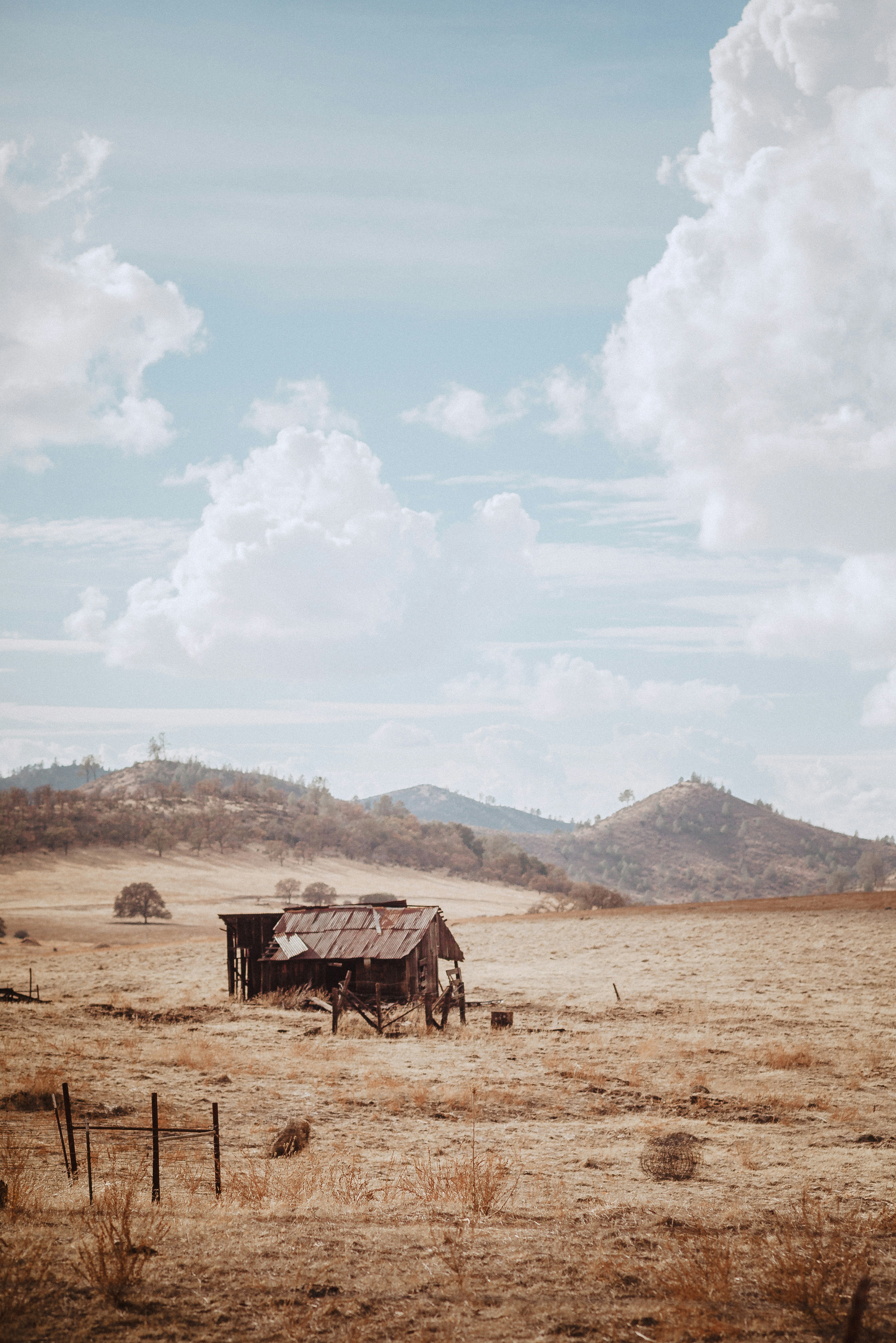 an old shack sitting in the middle of a field