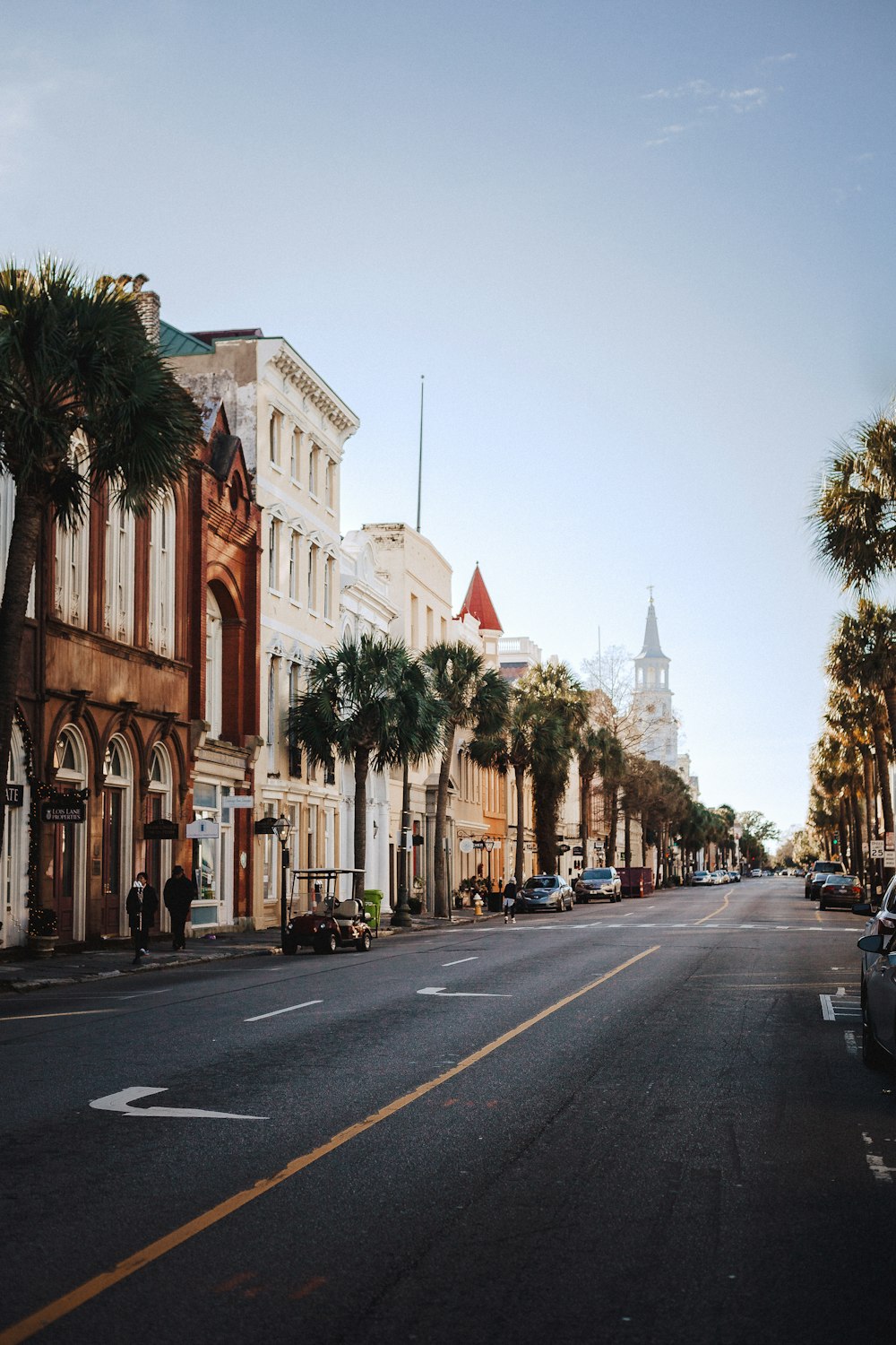 a street lined with tall buildings and palm trees