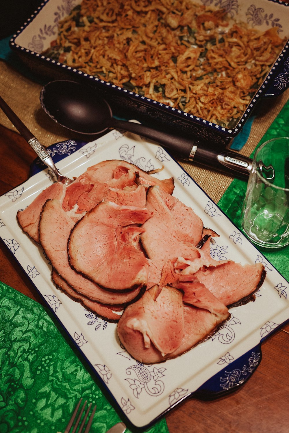 a plate of meat on a table next to a glass of water