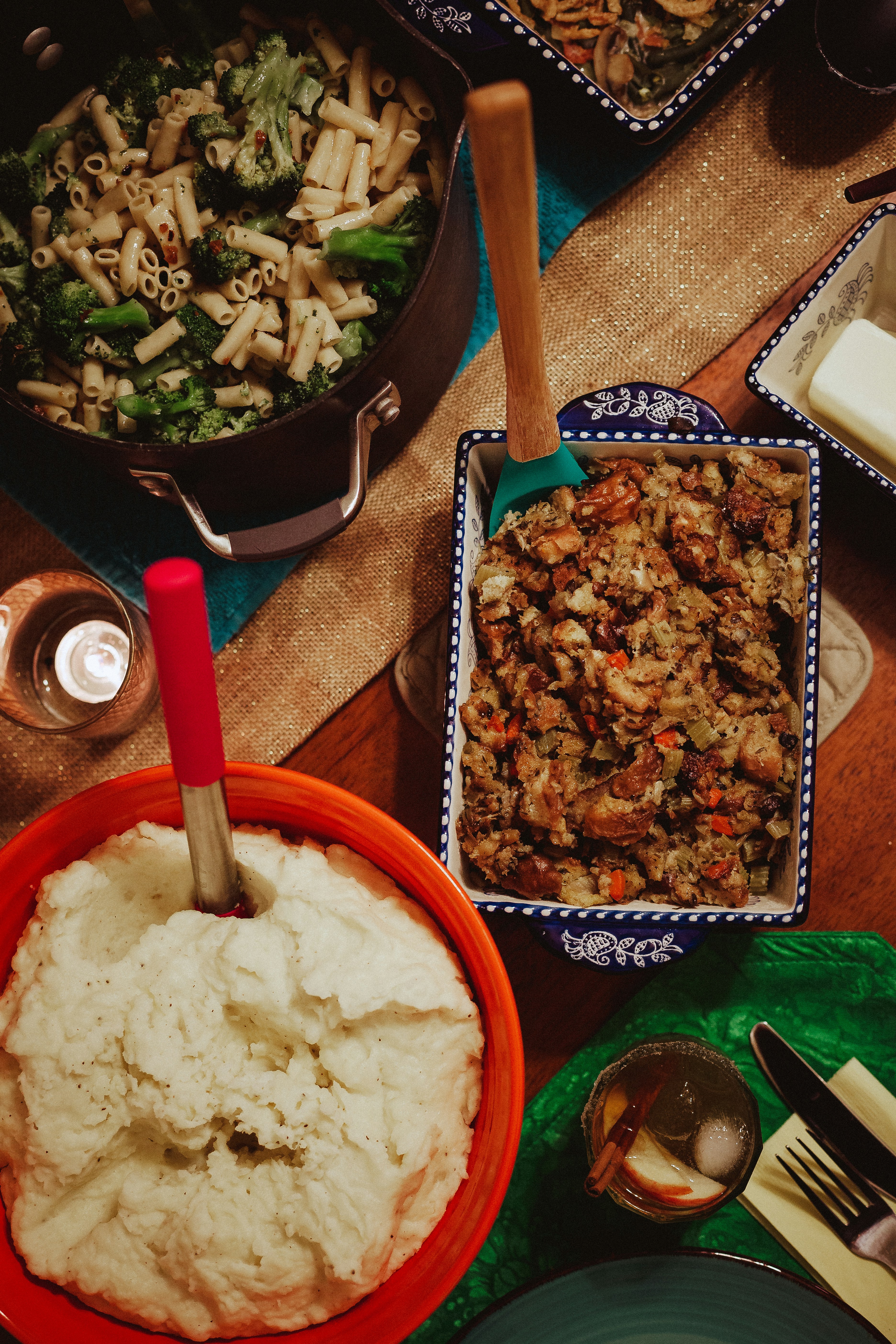 a table topped with plates of food and a bowl of mashed potatoes