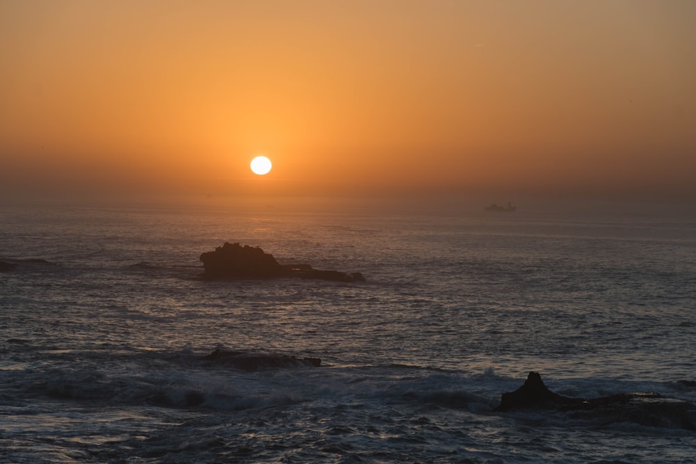 Il sole sta tramontando sull'oceano con le onde