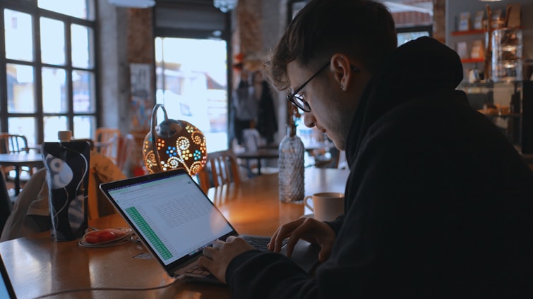 a man sitting at a table using a laptop computer