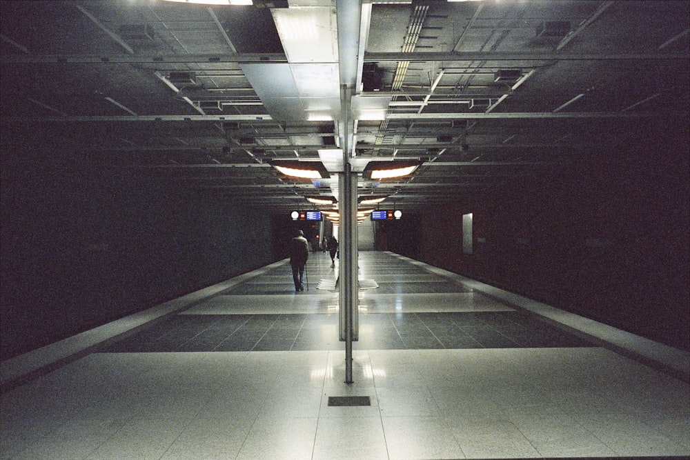 a person walking down a long hallway in a building