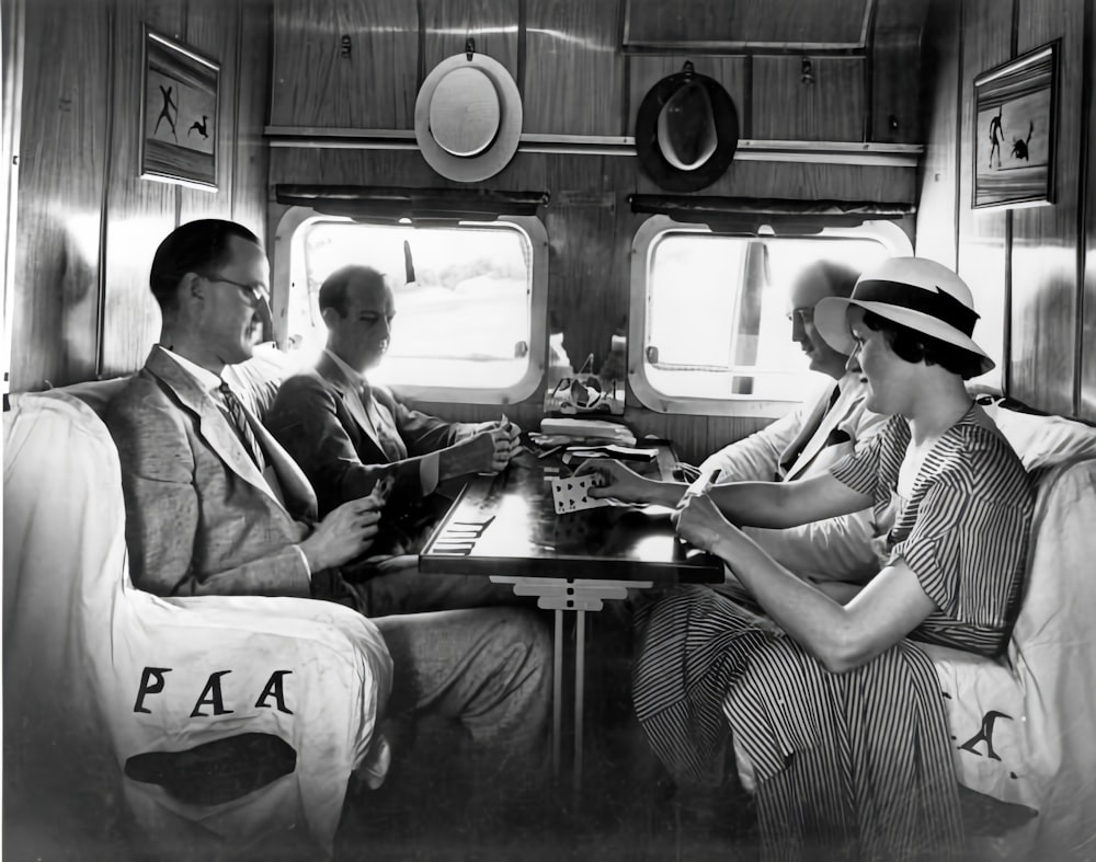 a black and white photo of three people on a train