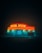 A neon-lit store stands illuminated in the night. The bright lights, in contrasting red and yellow hues, advertise services like payday advances and loans. The scene is enveloped in darkness, creating a mysterious and moody atmosphere, with fog adding to the surreal ambiance.