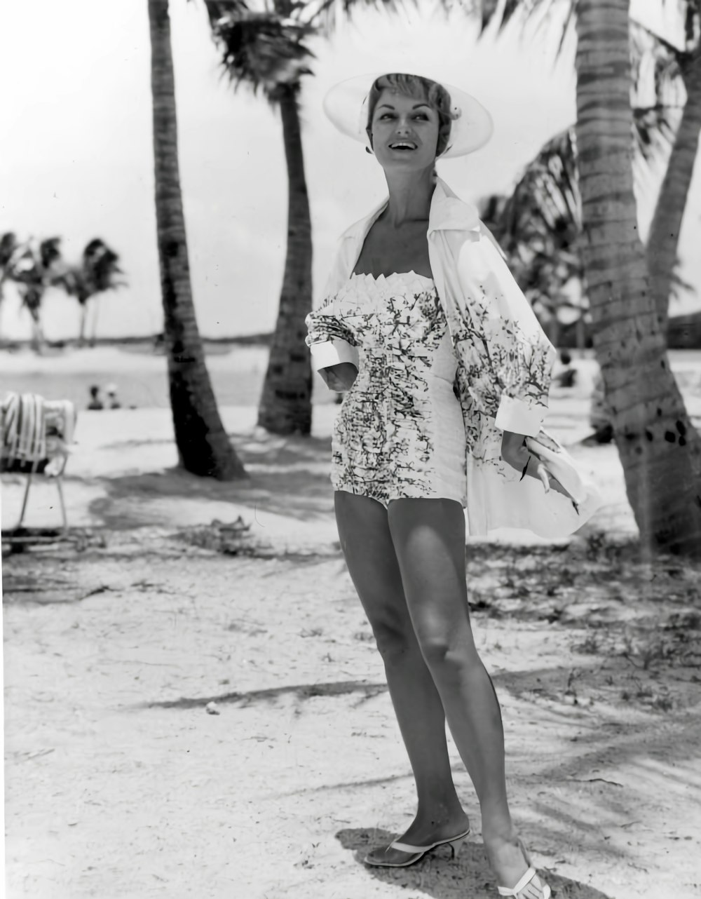 a black and white photo of a woman on the beach