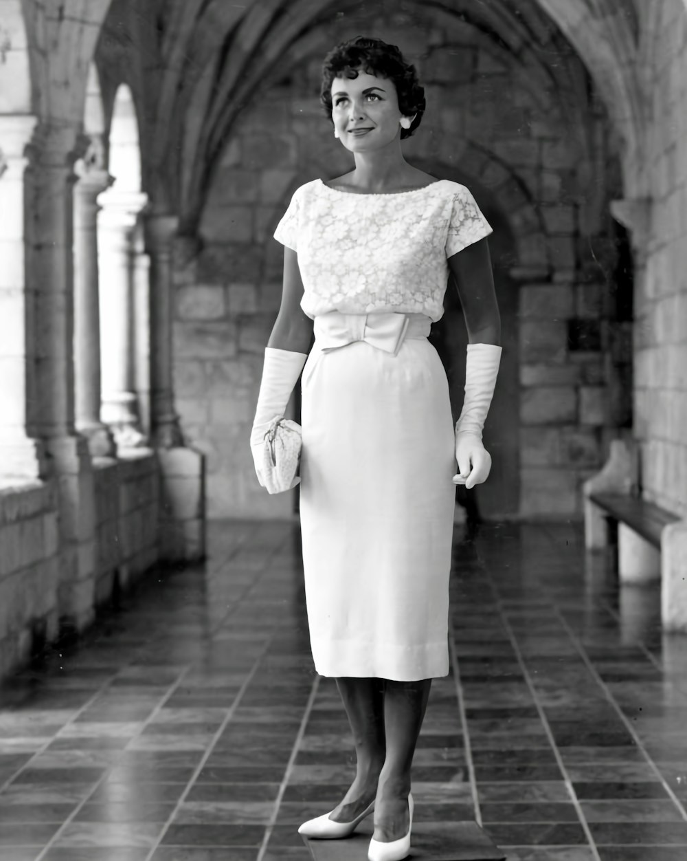 a woman in a white dress and gloves