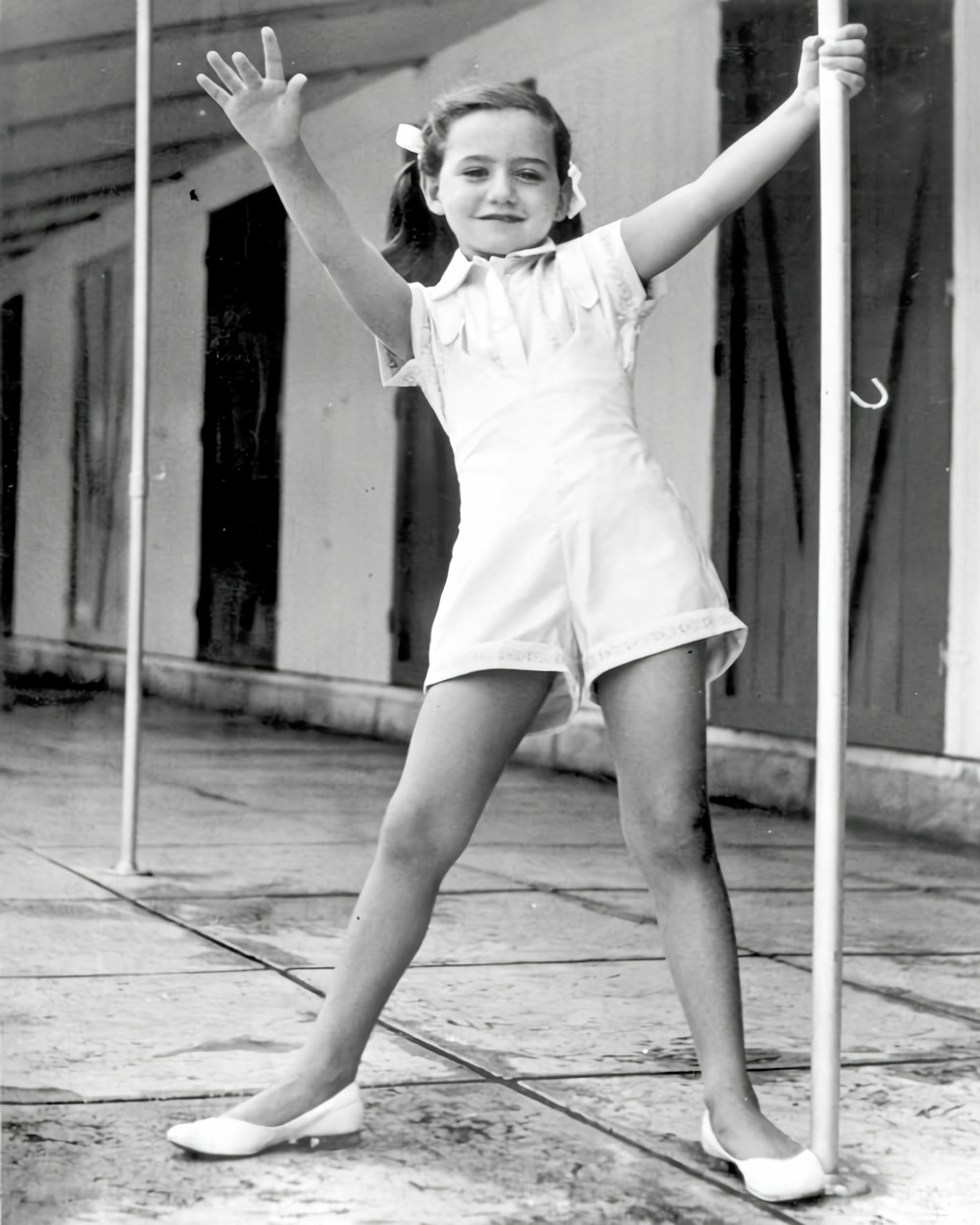 a young girl is holding a pole and posing for a picture
