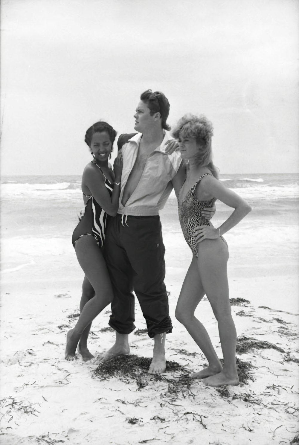 a group of people standing on top of a sandy beach