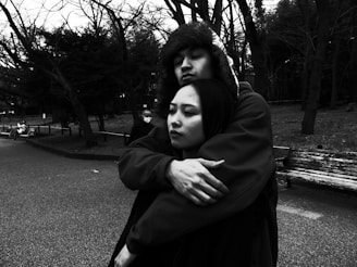 A serene black-and-white portrait of a couple sharing a quiet moment outdoors.