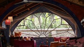 Spacious guest room featuring a plush bed and large window overlooking Islamabad greenery.