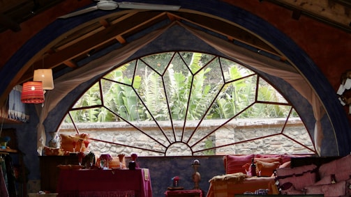 Spacious guest room featuring a plush bed and large window overlooking Islamabad greenery.