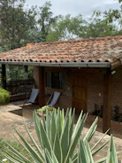 Inviting garden terrace with rustic furniture and lush greenery surrounding a quaint vacation home