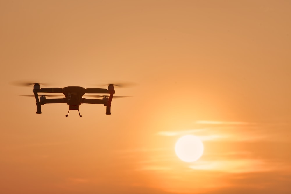 a small plane flying in front of the sun