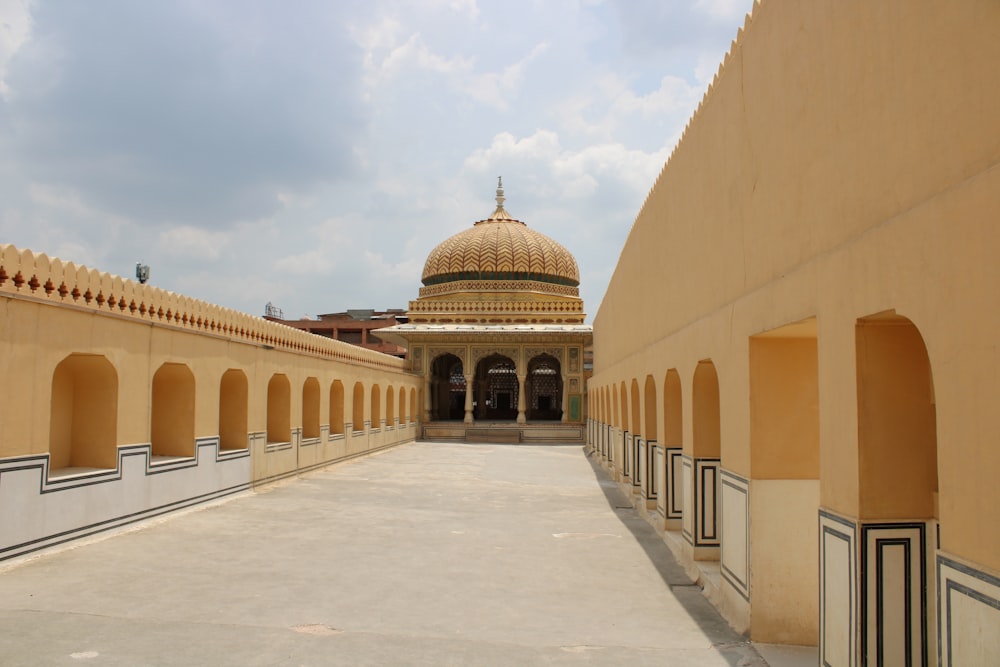 a building with arches and a dome in the background