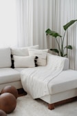 a living room with a white couch and pillows