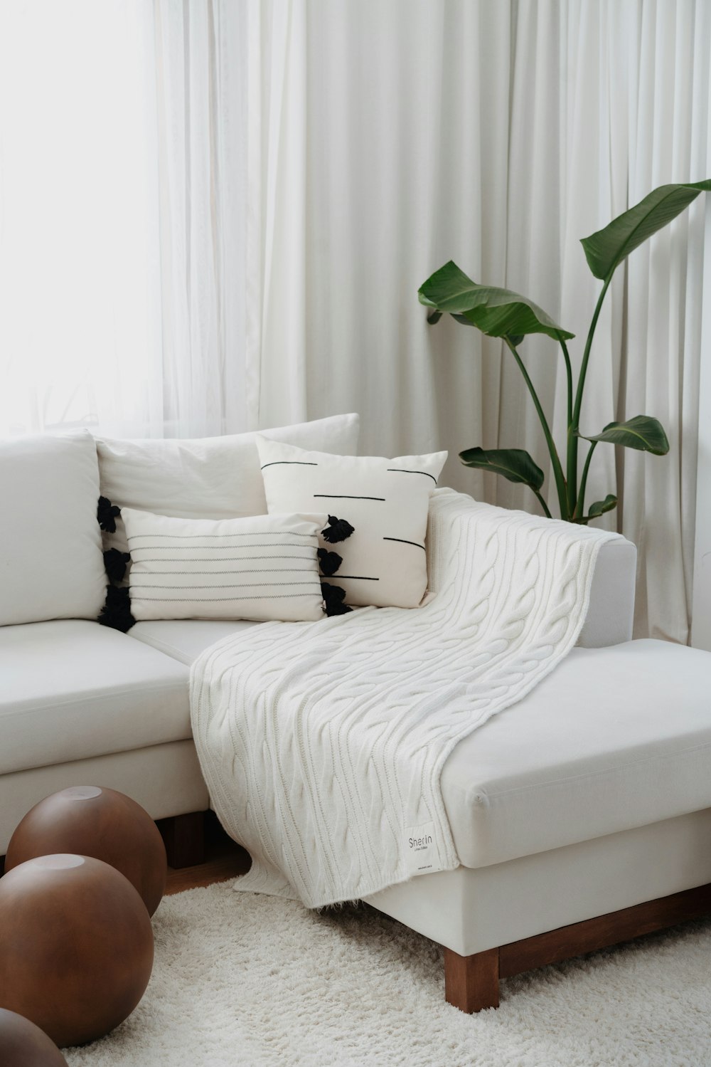 a living room with a white couch and pillows