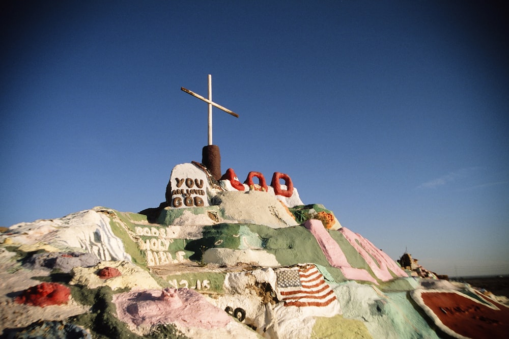 a cross on top of a hill with a sky background