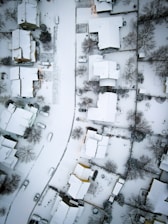 an aerial view of a neighborhood covered in snow